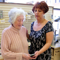 Photo of an SRSB client asking a member of SRSB staff for advice about equipment
