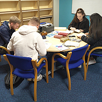 Photo of some students looking at some old books