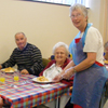 Photo of a volunteer serving lunch to clients
