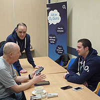 Photograph of previous Guru Day at SRSB showing people chatting about a device