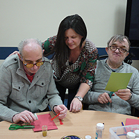 Photograph of clients and staff working on a craft activity in the group