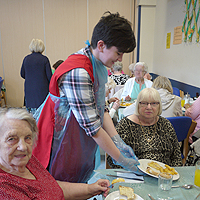 Photograph of a volunteer with clients in the activities centre