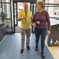 Photo of a volunteer guiding someone with sight loss