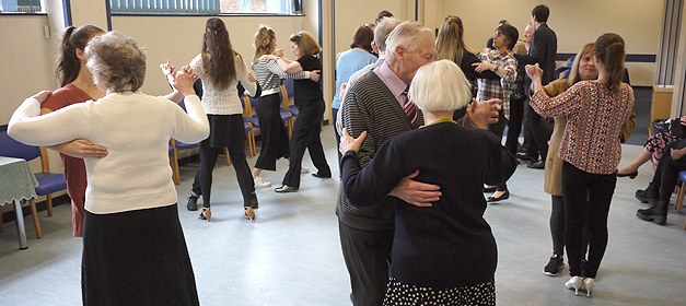 Blind and partially sighted clients dancing with volunteers at an SRSB client event