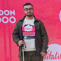 Photo of Bilaal in front of a banner