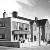 Black and white photograph of the front of Cairn Home showing the 1959 extension alongside the original 1935 building