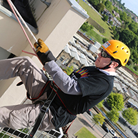 Photo of looking over the top of the building at someone abseiling down the building