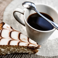 Photo of a cup of coffee and a slice of cake