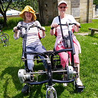 Photo of two people on a side by side bike