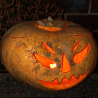 Picture of  a carved out pumpkin with a scary face lit up