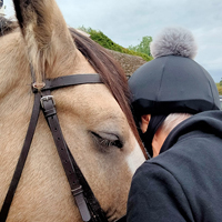 Photo of one of our clients hugging a horse