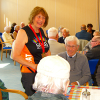Photograph of Pat showing her medal to clients at SRSB