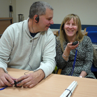 Photograph of clients using audio headsets
