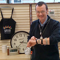 Photograph of Rob in Equipment Centre with lots of watches on his arm