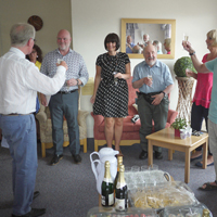 Photograph of group of trustees and staff toasting Kevin