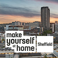 Photo of Sheffield centre from a distance, with a red sky and lots of buildings