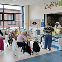 Photo of people siting at tables in the cafe