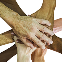 Photo of several hands all placed on top of each other