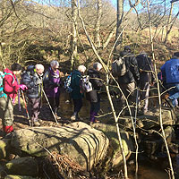 Photograph of walking group crossing a stream 