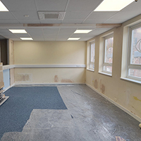 Photo of a corridor with rooms going off it. There is new carpet in the rooms with fresk plaster on the walls the rooms are empty
