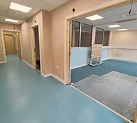 Photo of a corridor with rooms going off it. There is new vinyl flooring in the corridorand new carpet in the rooms with fresk plaster on the walls the rooms are empty