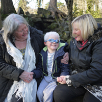Photograph of a young client with mother and grandmother