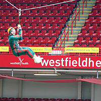 Photograph of a supporter taking part in a zip wire