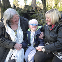 Photograph of one of SRSBs young clients with his mum and grandma