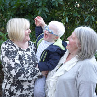 Photograph of one of SRSBs young clients with mum and grandma