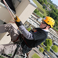 Photo of someone going over the side of a building showing the ground in the distance underneath