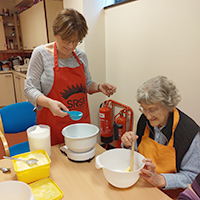 Photo of a volunteer and a client cooking