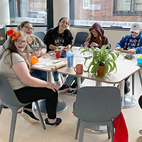 Photo of some young people sat around a table in a previous group