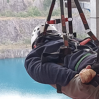 Photo of someone about to set off on a Zip Slide looking out over a lake below them